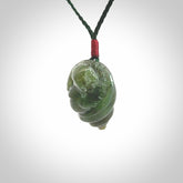 This photo shows a Buddha pendant hand carved in New Zealand Jade. It is provided with an adjustable manuka green cord.